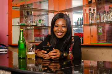 lady chilling in the bar using her cellphone feeling happy
