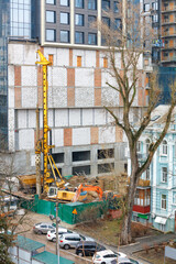 Naklejka premium A heavy excavator along with a drilling rig mechanism works at a construction site.