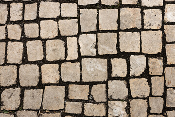 Mosaic of small marble cubes. sidewalks and squares formed by stone carpet with squares. Old cobblestones. High quality photo