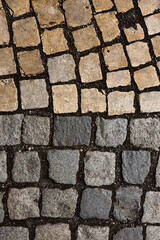Mosaic of small marble cubes. sidewalks and squares formed by stone carpet with squares. Old cobblestones. High quality photo