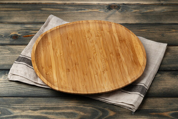 Wooden board with kitchen napkin on dark wooden table