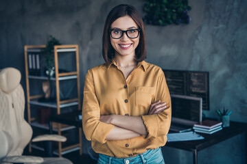 Portrait of attractive skilled smart cheerful girl folded arms developing web project at workplace...