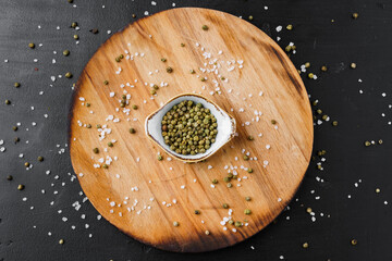Bowl with spice on wooden board top view
