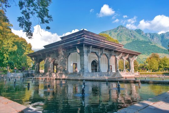 Beautiful picture of a historical monument in world famous Shalimar garden in Srinagar, Kashmir with blue sky, mountains and water bodies around