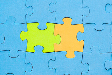 Green and yellow jigsaw puzzle pieces stands out from the crowd
