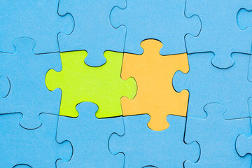 Fototapeta premium Green and yellow jigsaw puzzle pieces stands out from the crowd