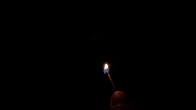 The match is lit in the dark on black background. HD slow motion