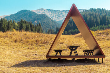 Modern gazebo on a tourist trail with a picturesque view of the summer mountains