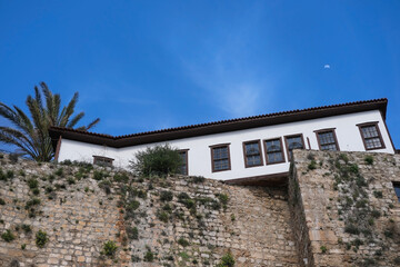 White private one-story house on stone wall against the blue sky and moon