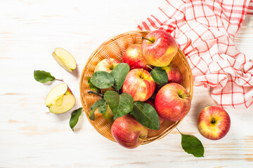 Fresh apples in the basket at white wooden table. Top view.