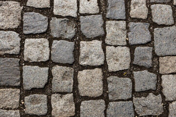 Mosaic of small marble cubes. sidewalks and squares formed by stone carpet with squares. Old cobblestones. High quality photo