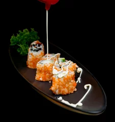 Tuinposter Top view of sushi roll with mayonnaise on black plate, focus selective © Kampol