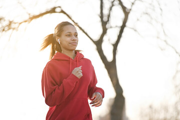 Young African american woman runner jogging outdoors in the park. Fitness, people and healthy...