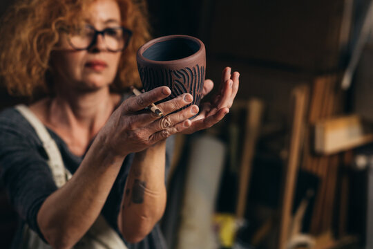 woman is making pottery in her workshop
