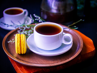 Hot tea with homemade macaroon cakes on a beautiful wooden dish.