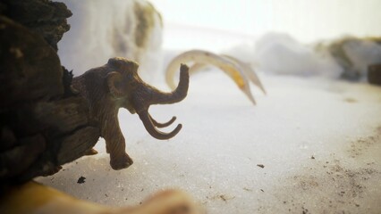Mammoth in a cold snowy landscape. Mammoth toy in the snow.