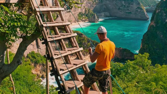 Travel people standing by scenery wooden hut on top tree and enjoy wonderful view on coastline tropical beach with crystal clear ocean water on nature background 4K