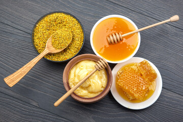 Fresh flower honey of different varieties, pollen and honeycomb with spoons on a wooden background. Organic Vitamin Health Food