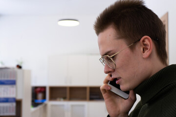 businessman in glasses talking on the phone in the office