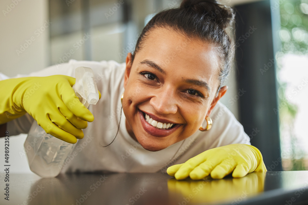 Poster Make that wood shine. Shot of a young woman cleaning a wood table.