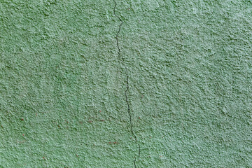 Textured green wall with a crack for design and lettering