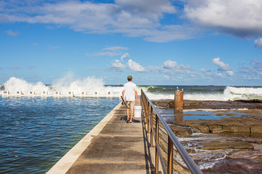 fisherman walking on pier at the sea