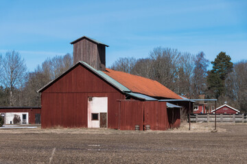 Obraz premium Tortuna, Sweden A red barn in a winter landscape.