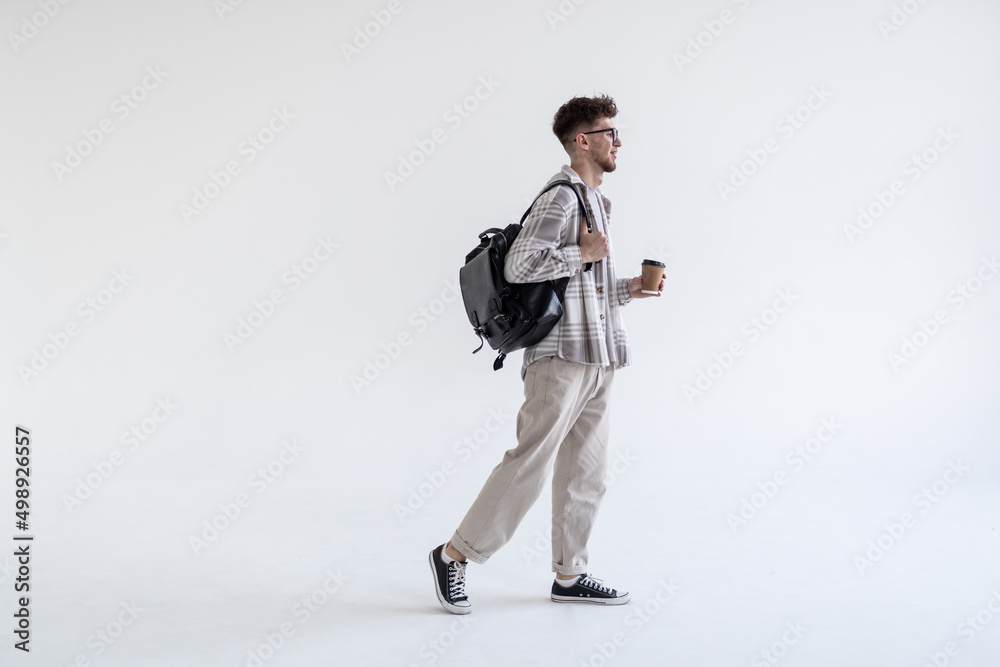 Wall mural Young man wearing bag walking isolated on white background