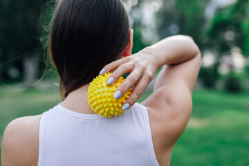 Young woman massage back with spiky trigger point ball, muscle pain treatment reflexology....