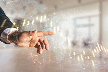 Multi exposure of man hand working with abstract financial diagram and world map on blurred office background, banking and accounting concept