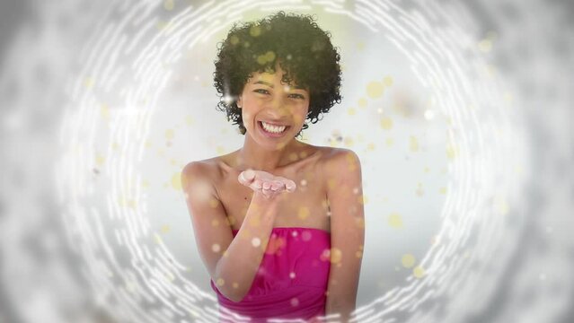 Animation of gold dots over happy biracial woman sending kisses