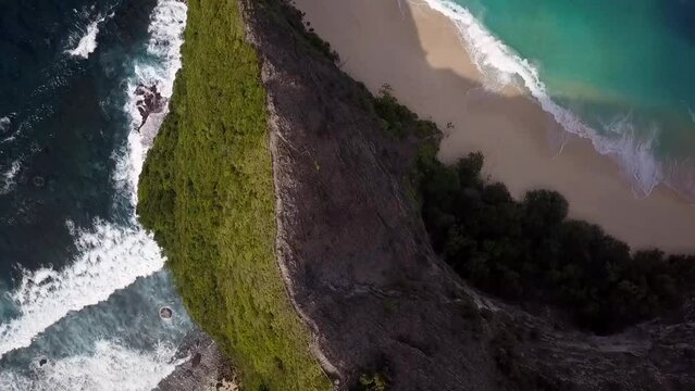 Amazing aerial view flight slowly circle camera pointing down drone shot peace
Kelingking Beach at Nusa Penida Bali Indonesia like Jurassic Park. Cinematic nature cliff view above by Philipp Marnitz