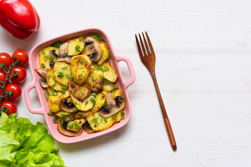 Bacon tartiflette on a baking dish with herbs and vegetables at home on a wooden white background. View from above. The national dish of potatoes. copy space
