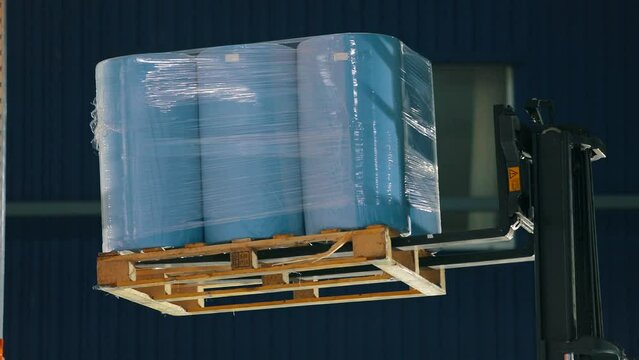 The forklift puts the goods on the shelf of the warehouse. The forklift puts the nonwovens on the shelf of the factory warehouse. Warehouse at the nonwovens factory.