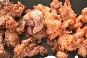 deep fried crispy salty chicken meat and gizzard on plate eat couple fresh lettuce vegetable salad