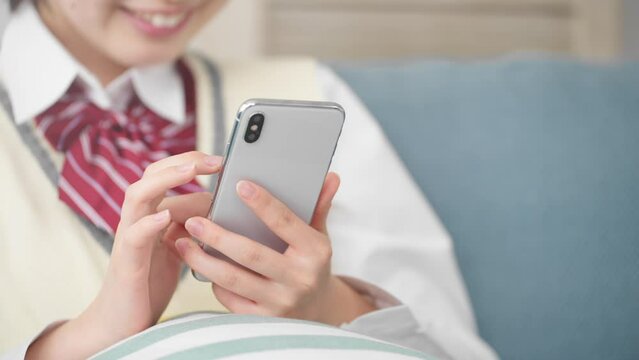 ファーでスマートフォンを操作する女子高生