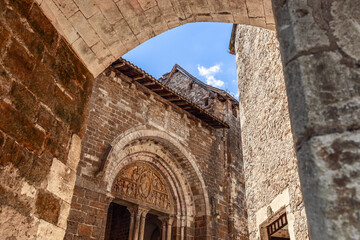 West face wall with columns entrance of church Eglise Saint-Pierre de Carennac decorated with medieval tympanum through marble stone arch. Lot, Occitanie, France