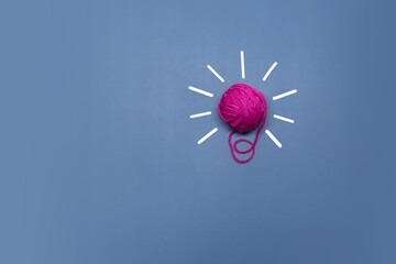 Creative thinking ideas and innovation concept. A ball of pink threads with a light bulb symbol on a violet background