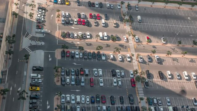 Aerial view of a parking lot with many cars in rows timelapse