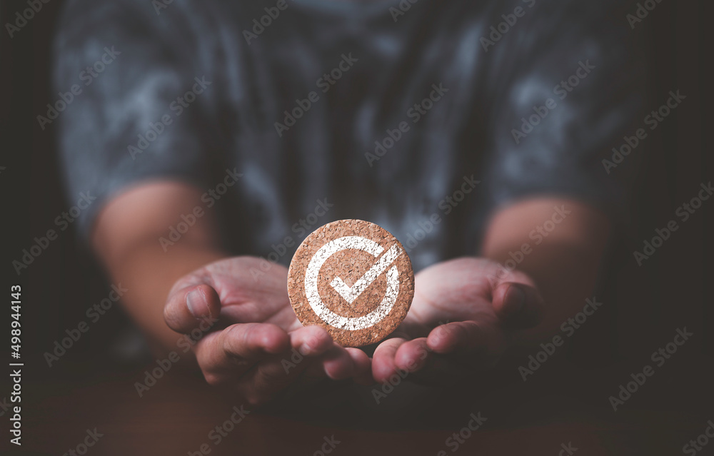 Poster Hand giving and showing the best quality assurance of correct sign which print screen on round wooden for guarantee product and ISO service concept.