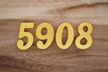 Golden Arabic numerals on a real brown and white wooden floor number 5908