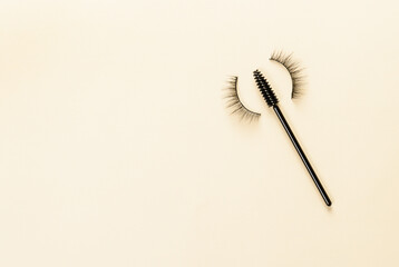 Overhead eyelashes and brushes on yellow background. Makeup of female eyes. Eyelash extension. Piece care.