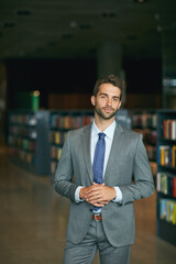 Fototapeta premium Are you ready to share some ideas. Cropped portrait of a handsome young businessman standing with his hands together in an empty library.