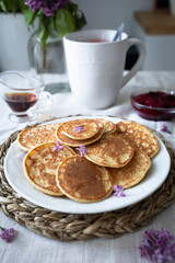 Delicious and healthy breakfast with mini pancakes, maple syrup and berry jam