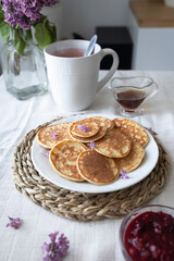 Delicious and healthy breakfast with mini pancakes, maple syrup and berry jam