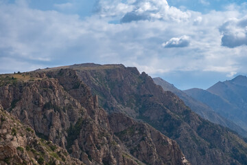Beautiful mountains with plateau ending with rocky cliff. Mountain valley landscape. Travel concept. Kora river mountain gorge. Travel, tourism in Kazakhstan concept.