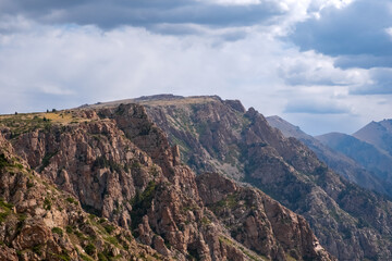 Beautiful mountains with plateau ending with rocky cliff. Mountain valley landscape. Travel concept. Kora river mountain gorge. Travel, tourism in Kazakhstan concept.