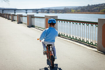 Obraz premium boy on a bicycle in a blue jacket and helmet 