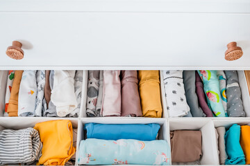 Baby's clothes neatly laid out in the chest of drawers. Organization of the children's closet....