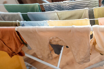 Baby's clothes, bodysuits and pants are dried after the laundry. Organization and cleaning in the children's room